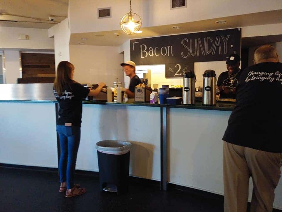 A customer stands at a coffee counter.