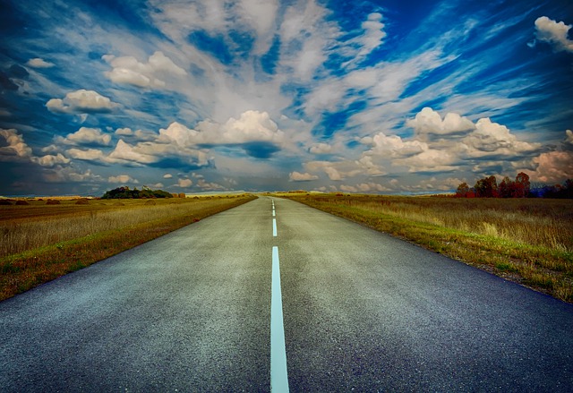 Image of an open road with clouds in the sky