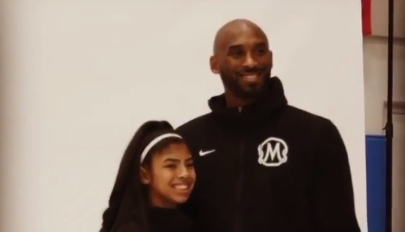 A picture of Kobe Bryant standing next to his daughter Gigi Bryant.