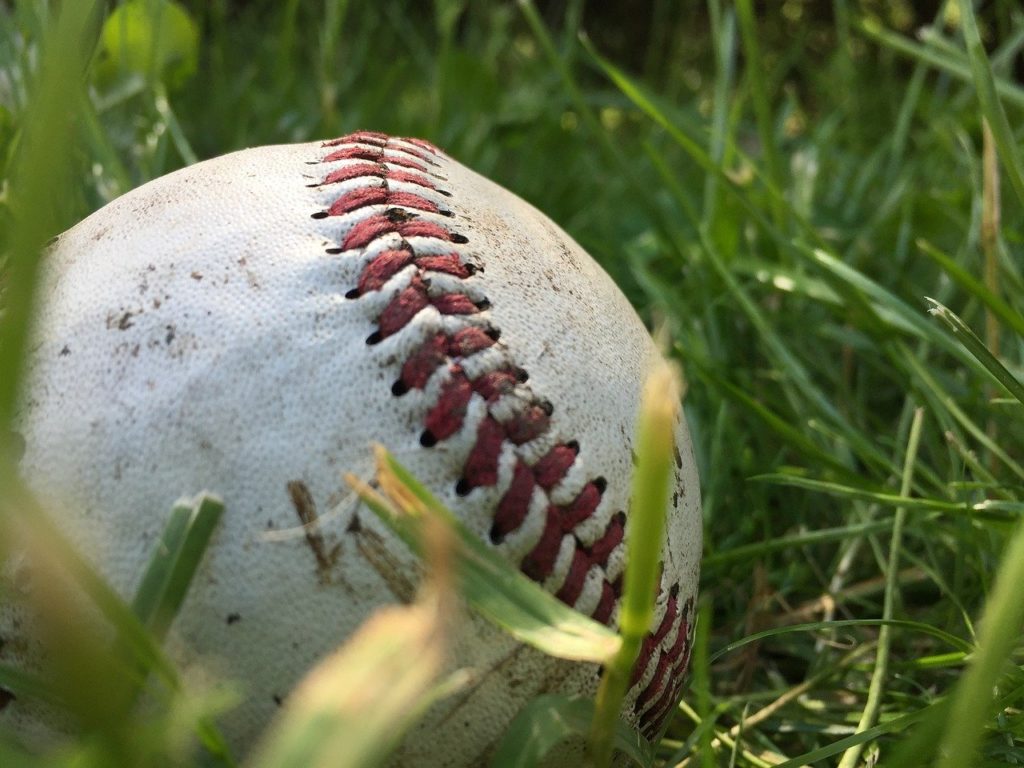 A dirty baseball laying in the grass