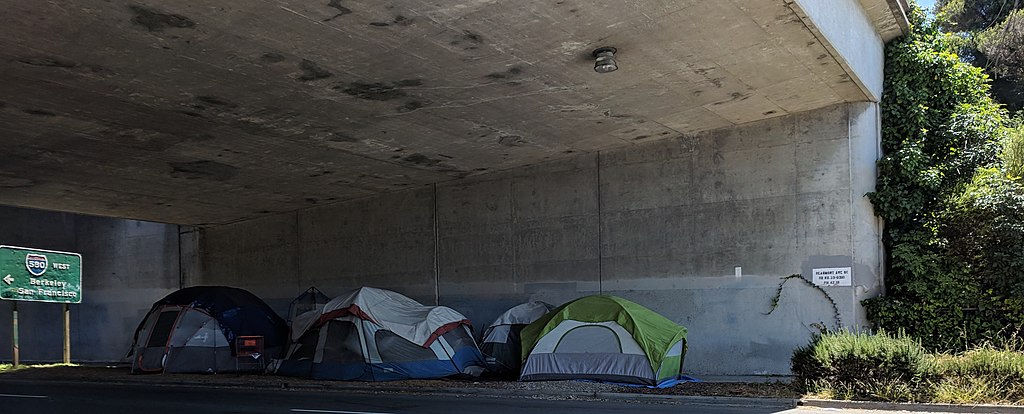 tents sit under a freeway underpass