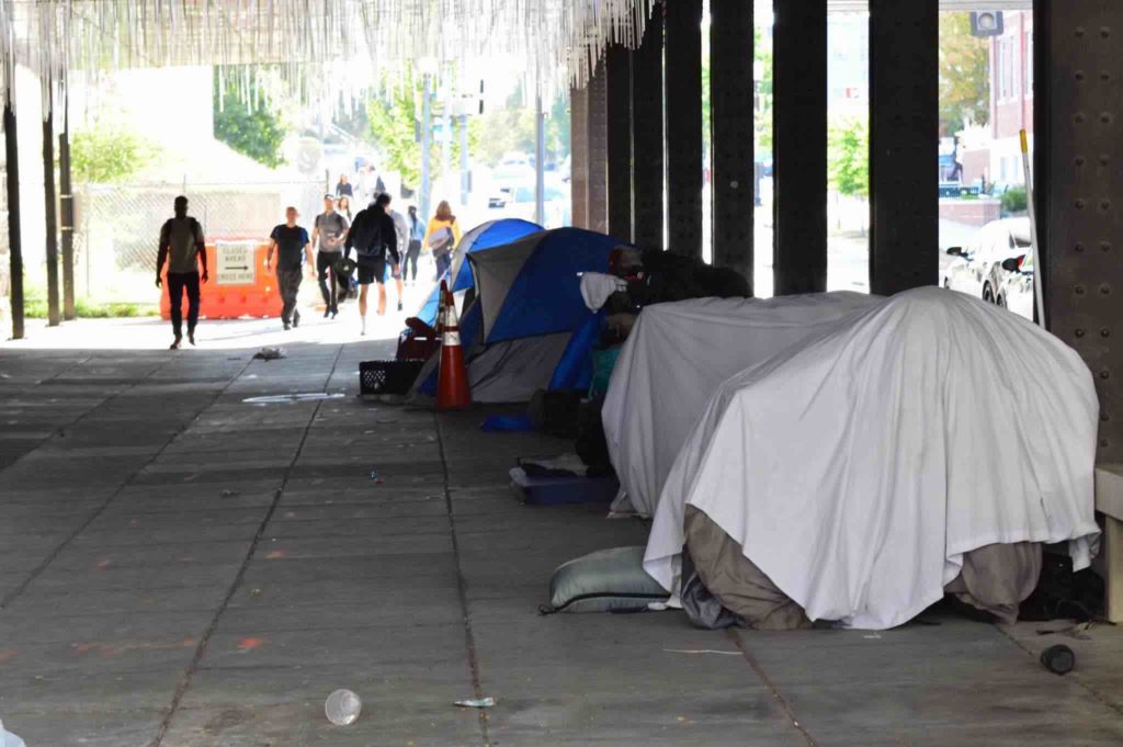 Tents under a freeway overpass.