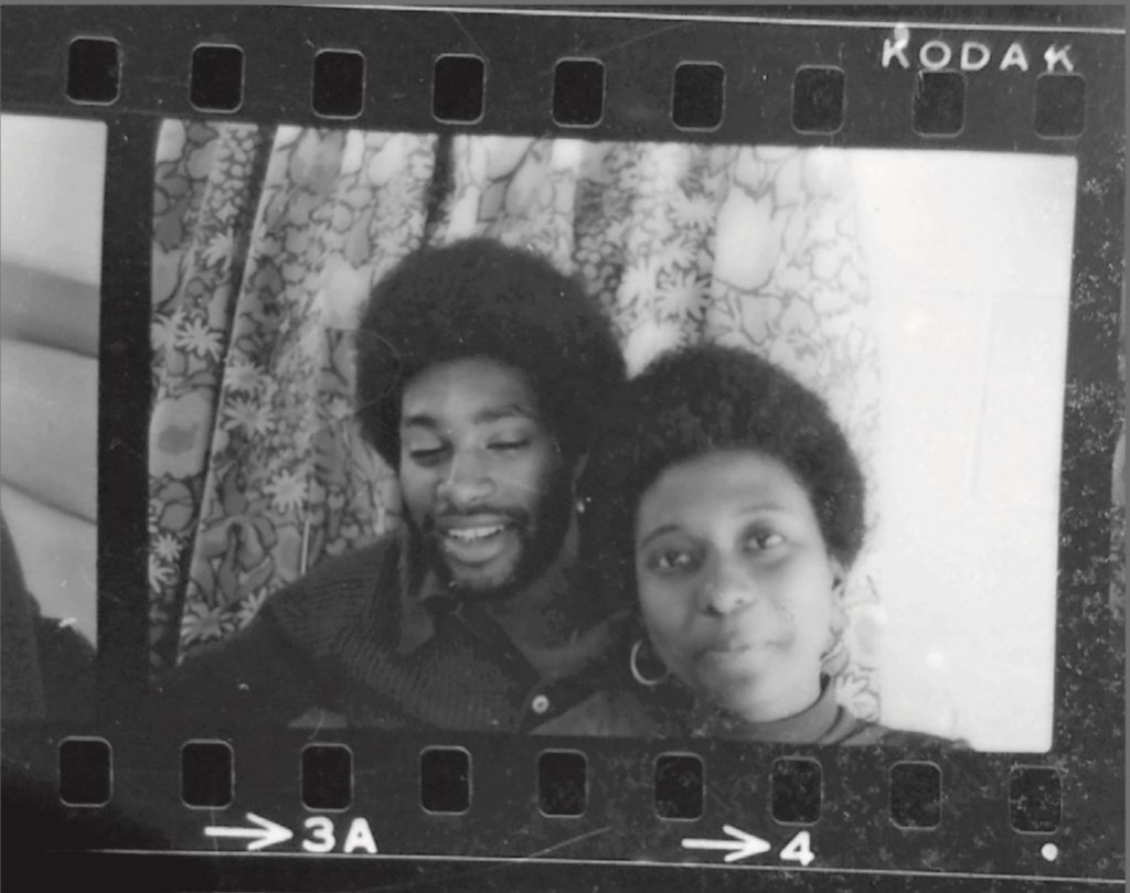 A photo negative of a young black men with his arm around a young black woman