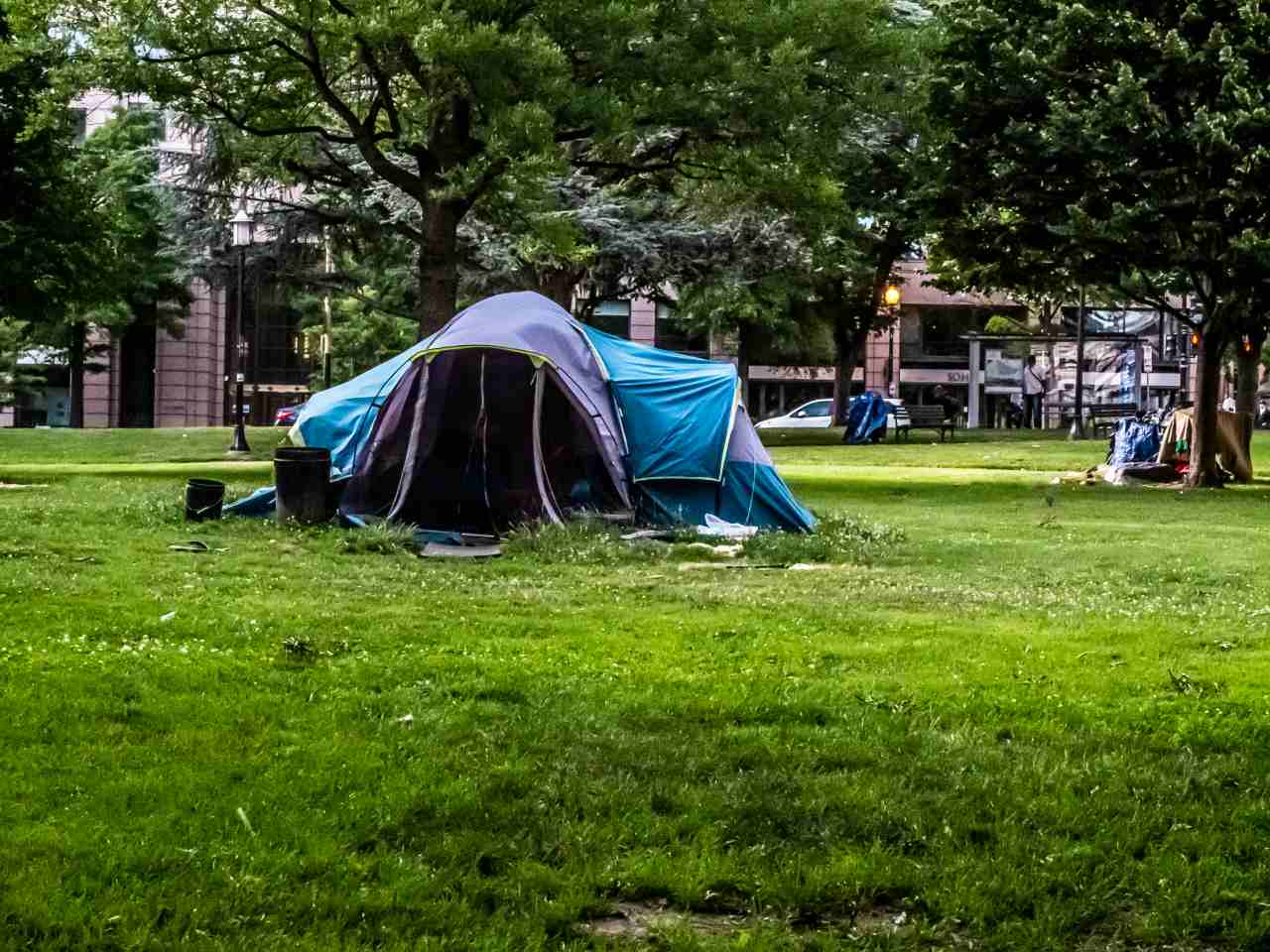 Photo of a large multi-person tent in the foreground and a smaller tent off in the distance.