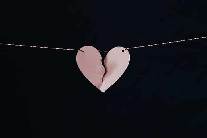 Photo of ripped paper heart on black background