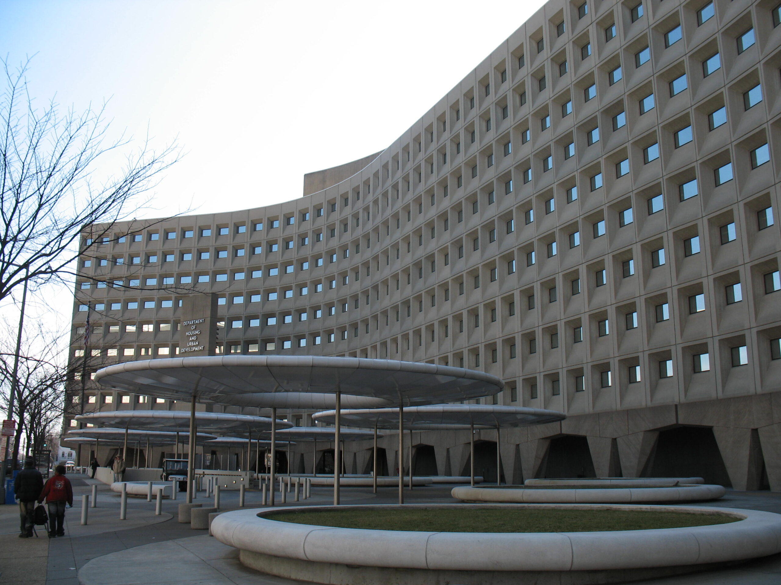 Photo of curved concrete government building with square windows.