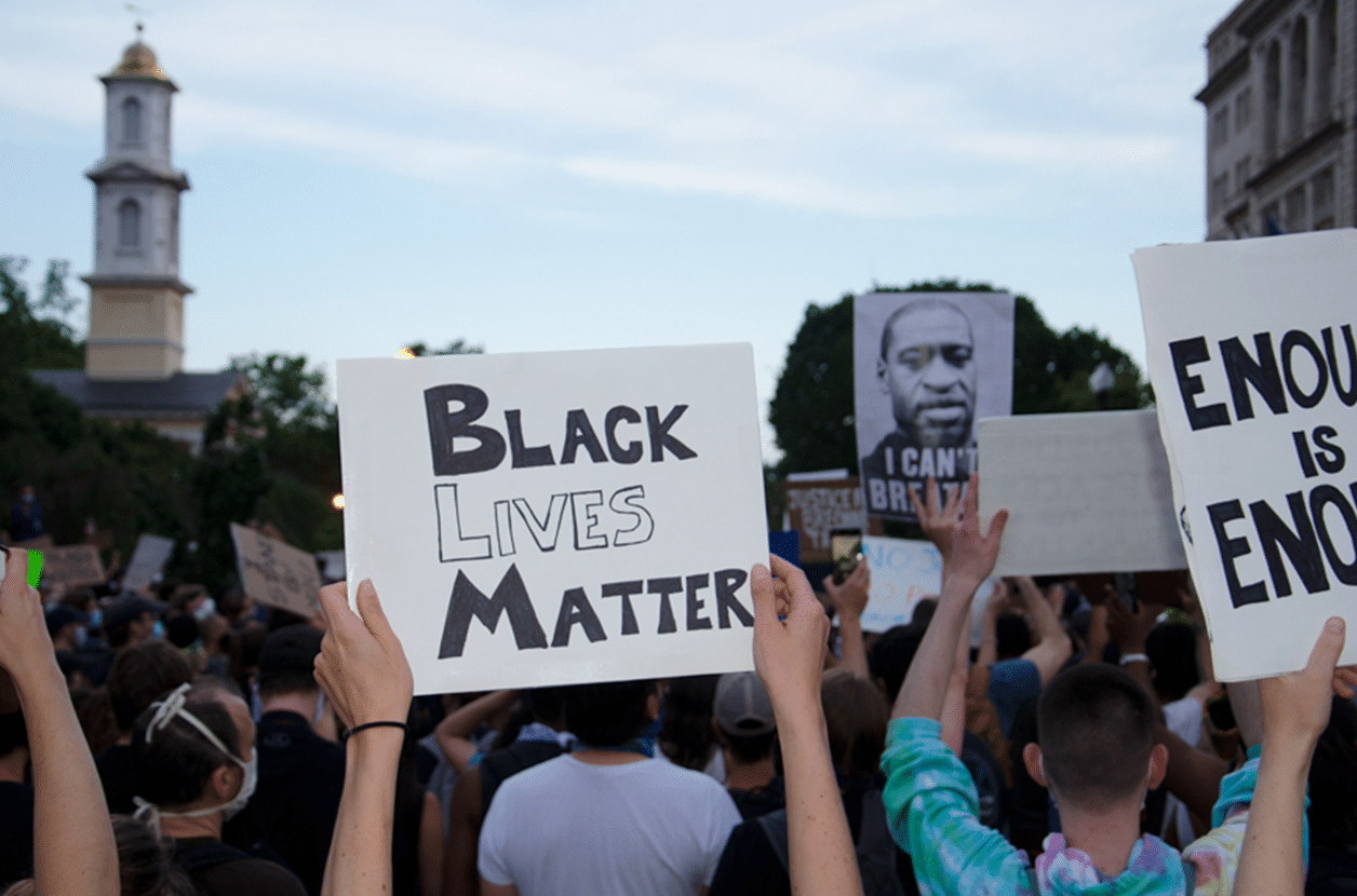 Photo of protesters holding a sign that reads "Black Lives Matter"