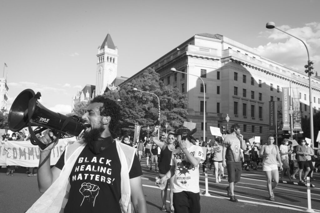 Black and white photo of man speaking into bullhorn