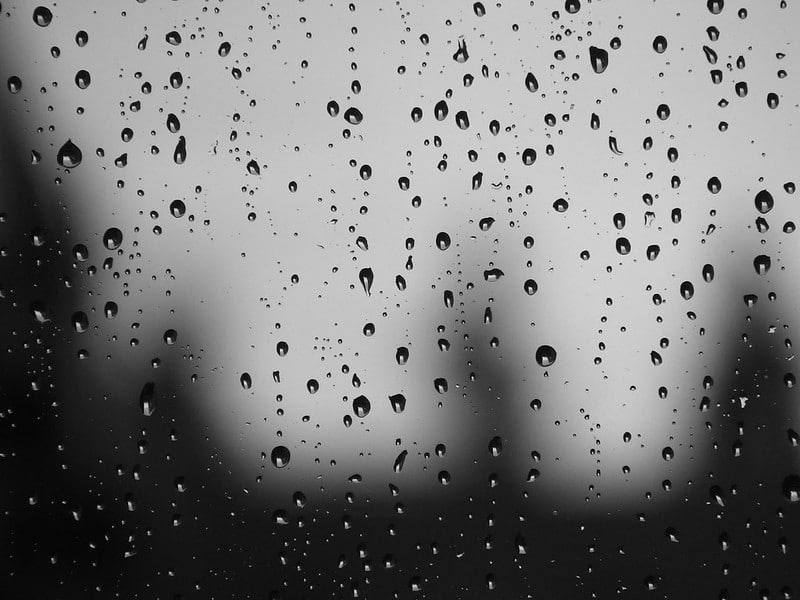 Black and white photo of rain drops on window