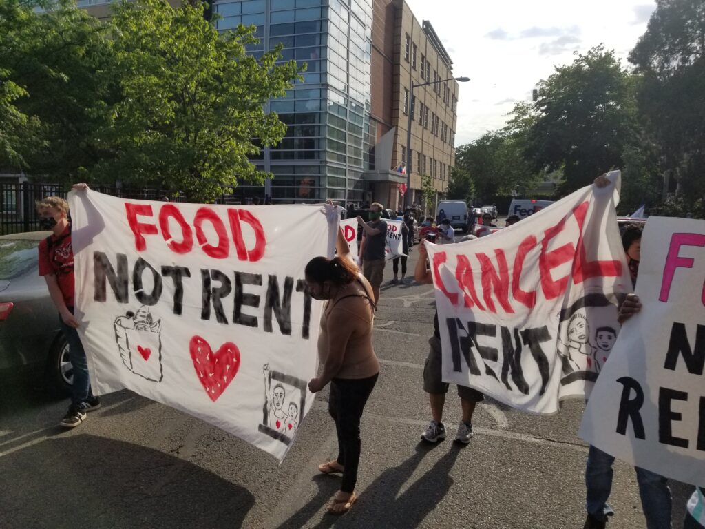 Photo of people holding up banners that read "food not rent" and "cancel rent"