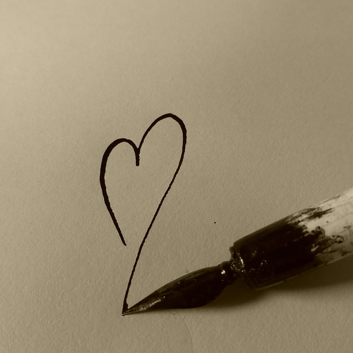 Image of a pen drawing a heart on paper