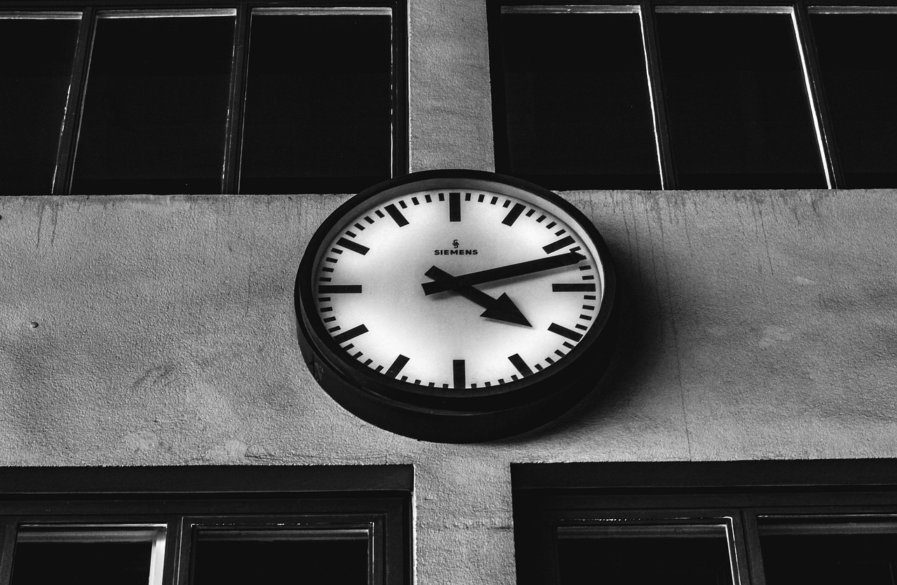 A black and white photo of a clock on a building.