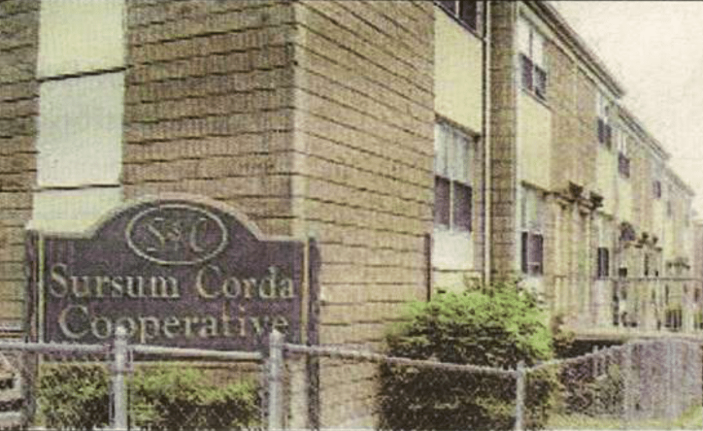 A photo of buildings with the sign 'Sursum Corda'