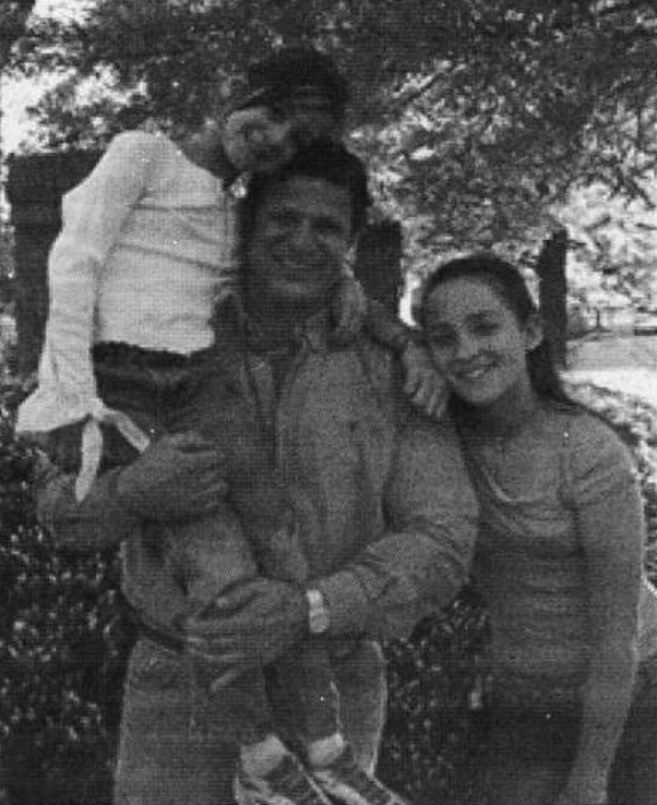 A man and two girls smile at the camera.