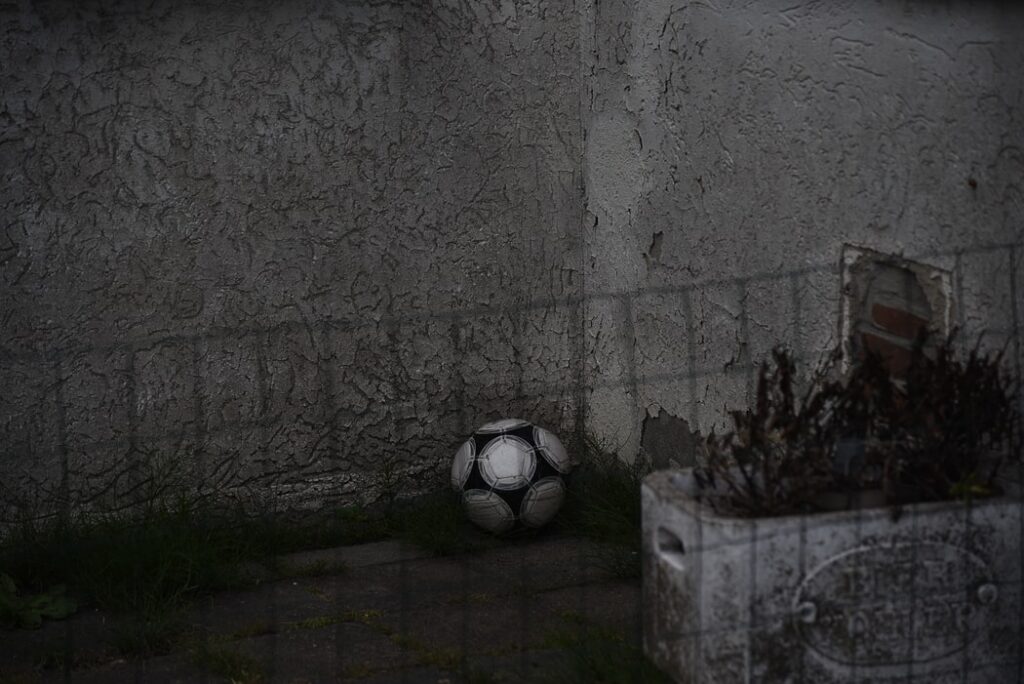 A soccer ball sits on the sidewalk.