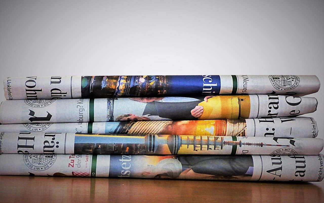 Image of folded newspapers piled into a stack.