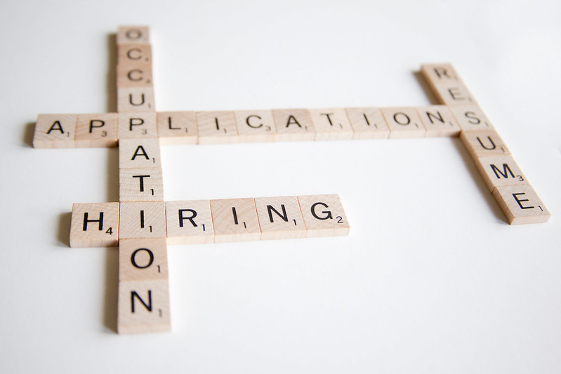 Photo of Scrabble tiles laid out to spell "occupation," "application," "hiring," and "resume."