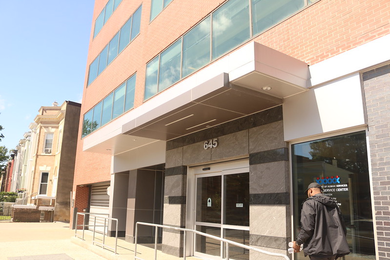 Photo shows the DHS service center, a brown building with windows, on a sunny day