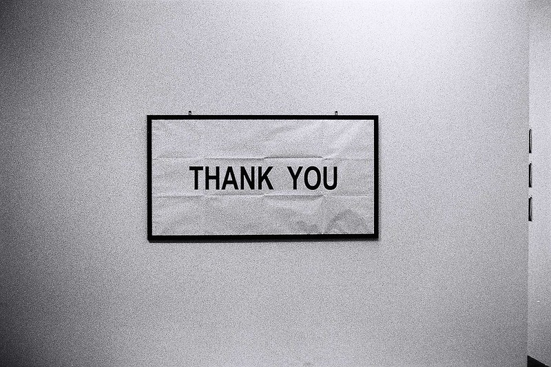 A photo of a simple white sign that says, "thank you"