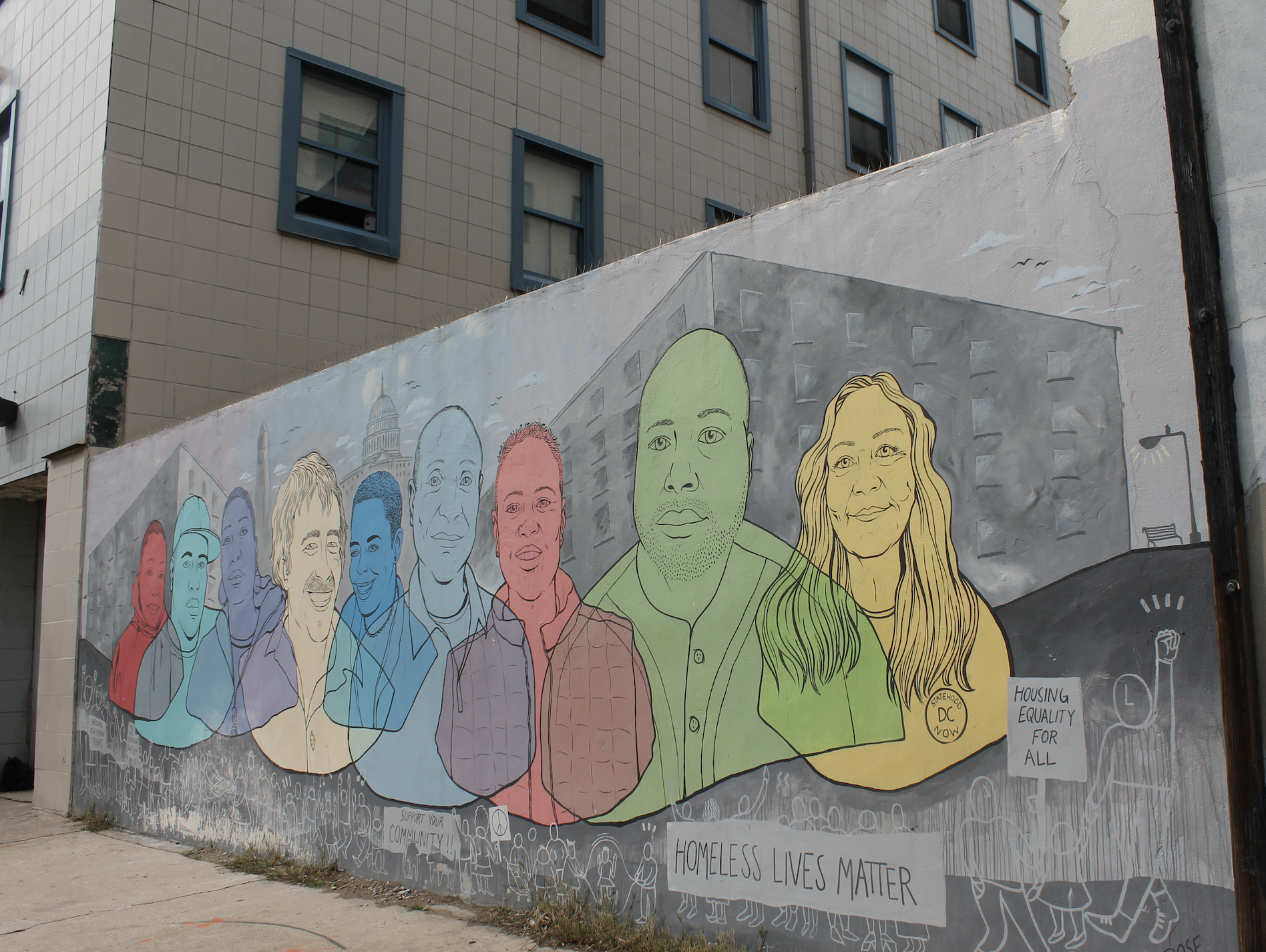 Photo shows the homeless lives matter mural at CCNV, with colorful faces