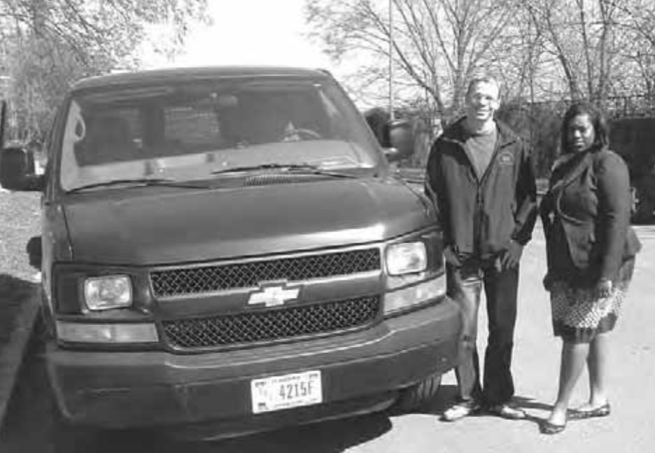 An image of two MCS employees next to a vehicle.