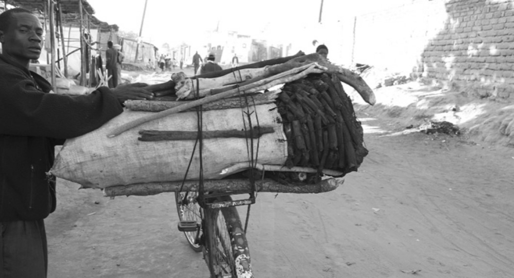 A Malawian man transports charcoal ashes on his bicycle.