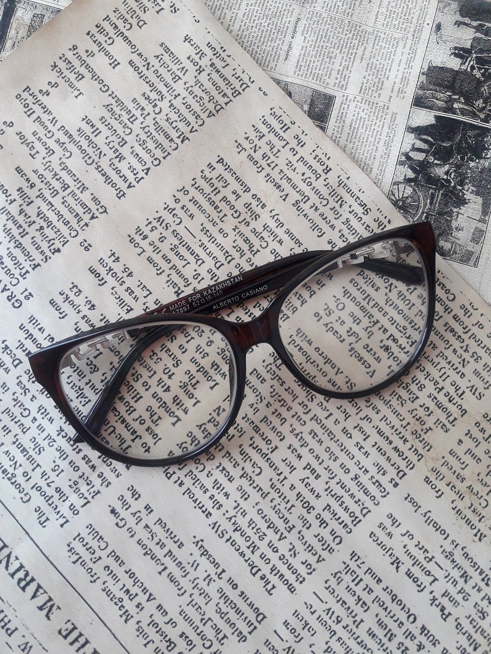 Image of eye glasses sitting on top of a newspaper