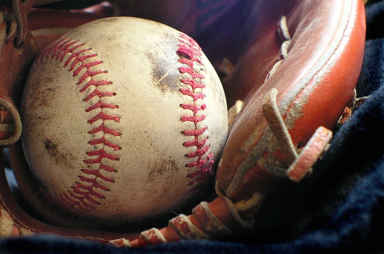 Photo of a baseball glove and a baseball.