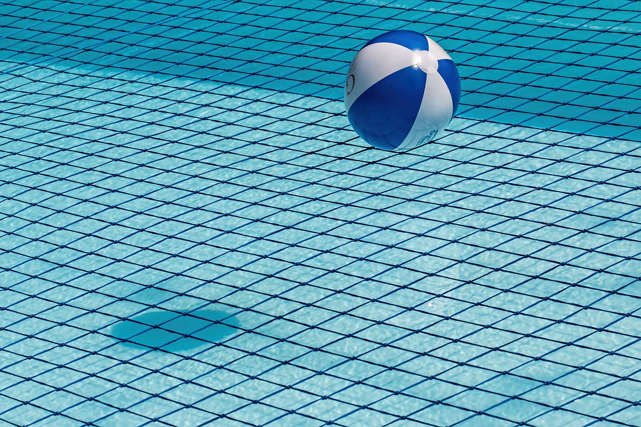 Image of a pool safety net and a beach ball about to fall into it.
