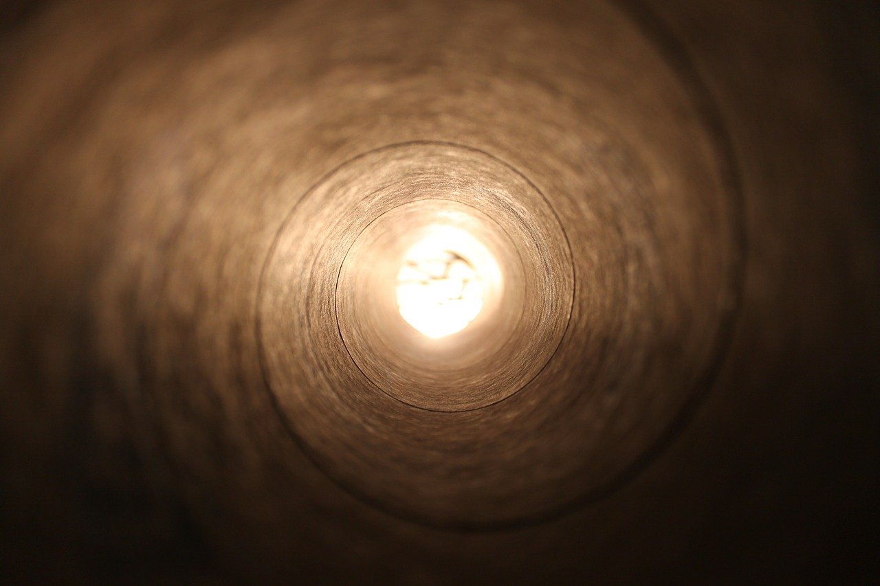 Image of a tunnel with a bright light at the end.