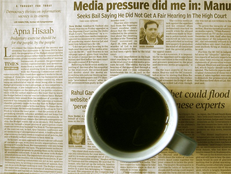 Photo of a cup of coffee sitting on top of a newspaper.