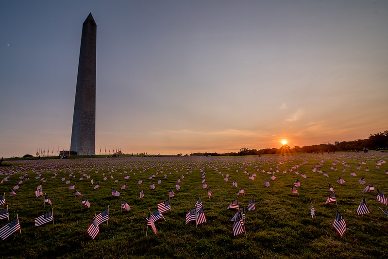 Photos of small American flags placed on the National Mall near the Washington Monument at sunset.