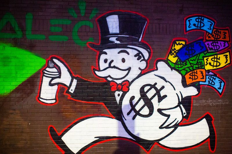 Mural of the Monopoly Mr. Pennybags mascot depicted as a mural running away with a bag of money.