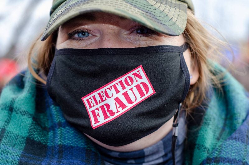 Photo of a female supporter wearing a mask that says "Election Fraud"