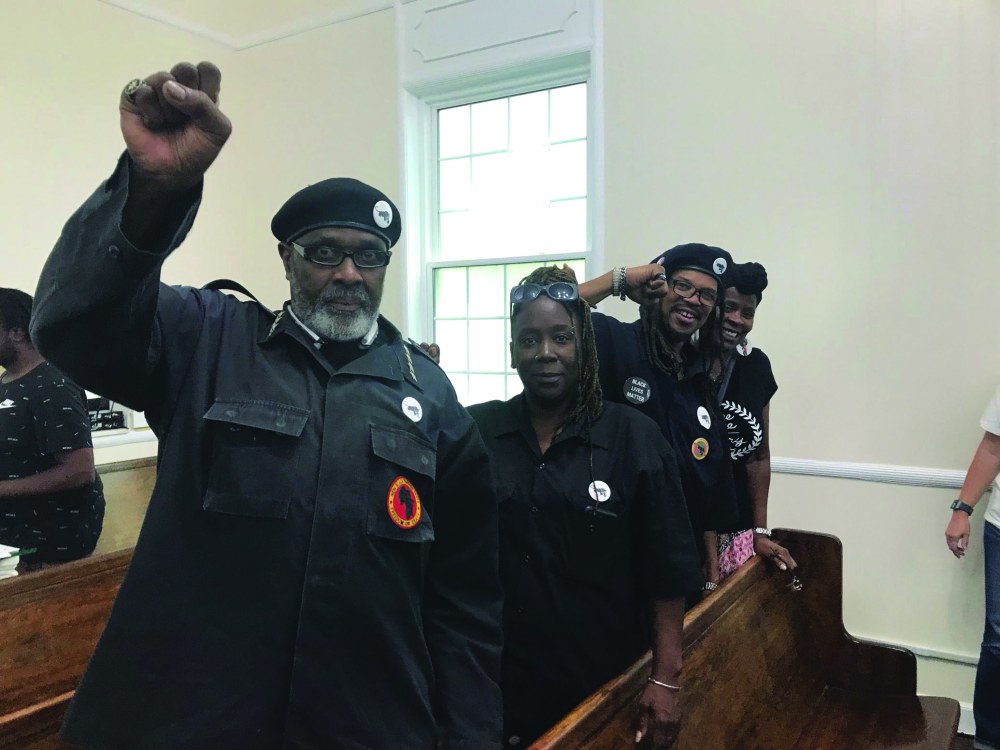 Photo of Pierre Johnson and other members of the New Black Panther Party at a church pew