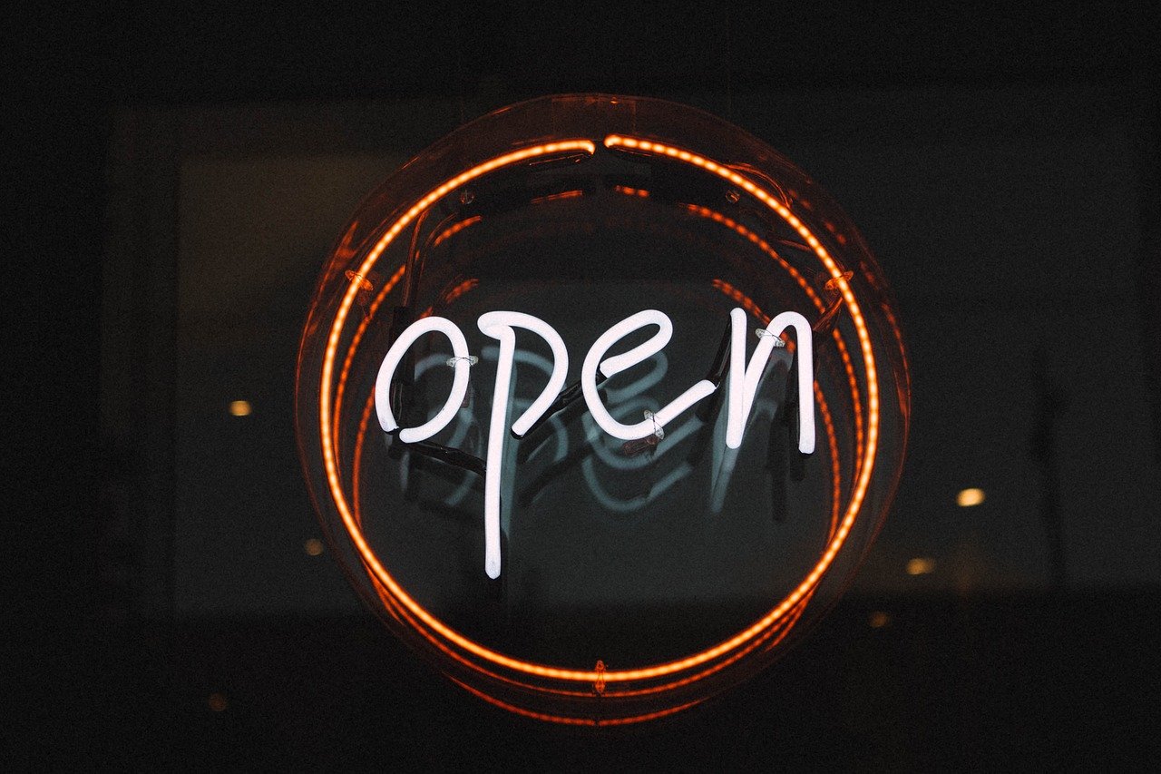 A photo of a neon open sign on the front of a business.