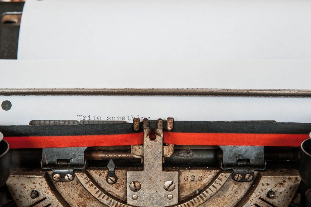 Photo of a typewriter with "write something" typed onto an otherwise blank piece of paper.