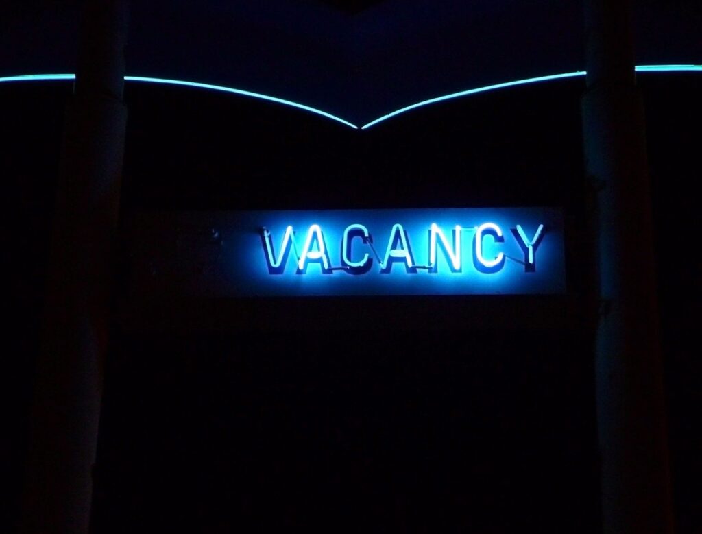 A photo of a vacancy sign in front of a hotel.