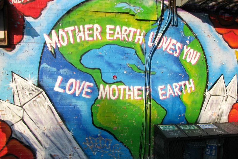 A mural depicting the planet Earth; the words "Mother Earth Loves You, Love Mother Earth" appears across it
