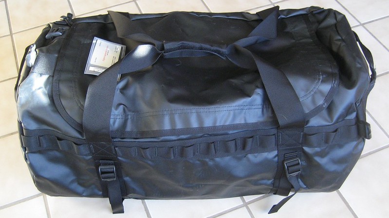 A photo of a black duffel bag sitting on the floor.