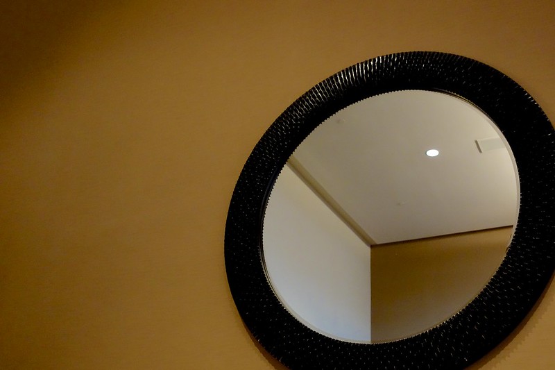 Photo of a mirror hanging on an otherwise blank wall