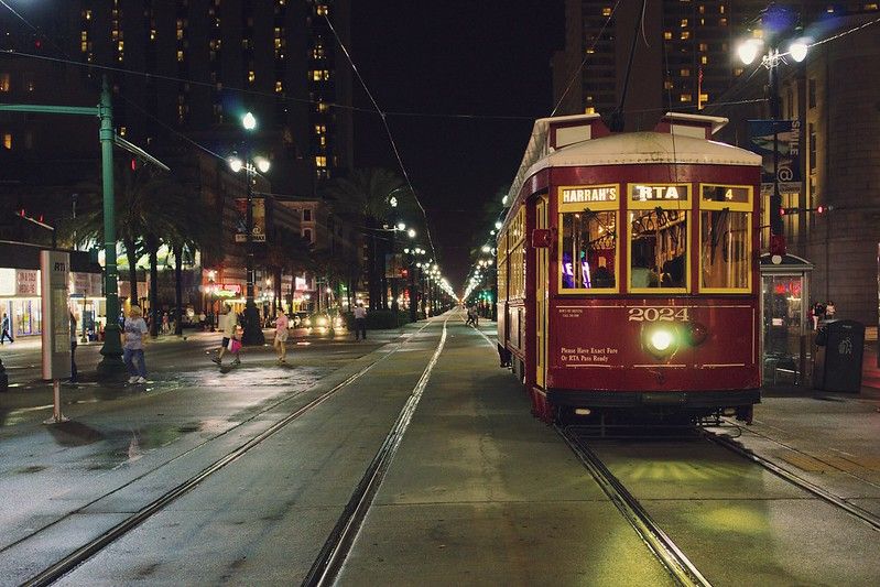 Photo of a NOLA Streetcar going down the tracks in New Orleans.