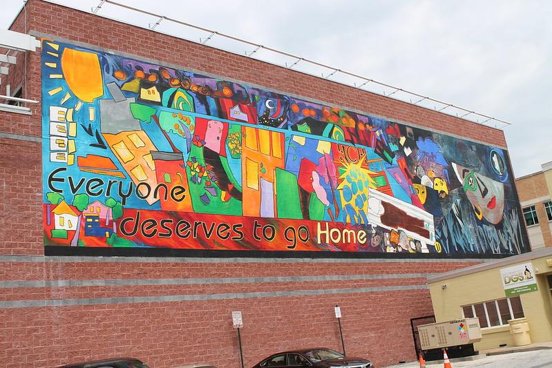 Mural depicting abstract art of housing with the phrase "Everyone deserves to go Home"