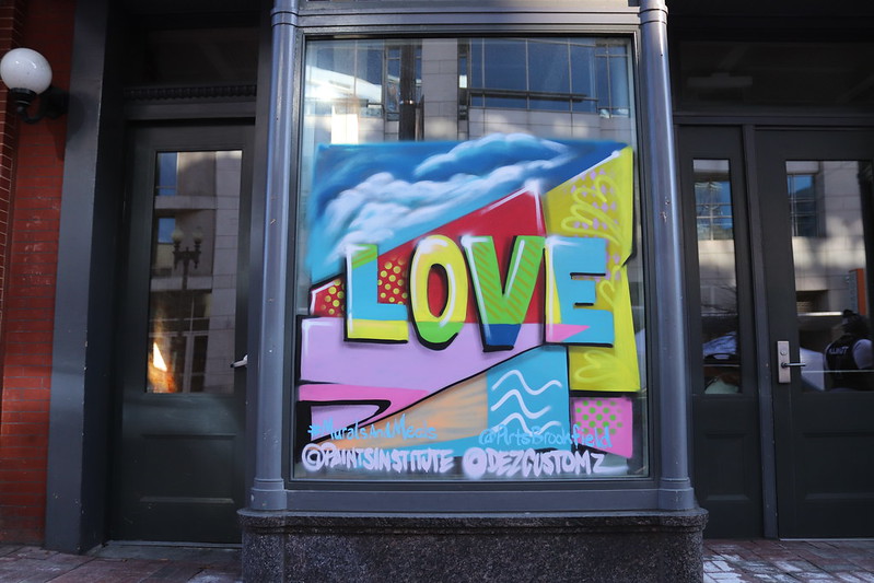 A colorful window mural that spells out the word LOVE.