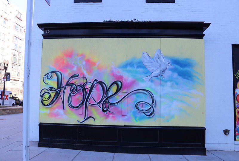 A photo of a temporary mural in DC that says "hope" in script with a white dove flying overhead.