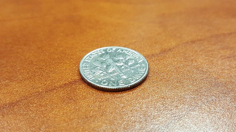 Photo of a single U.S. dime coin sitting on a table.