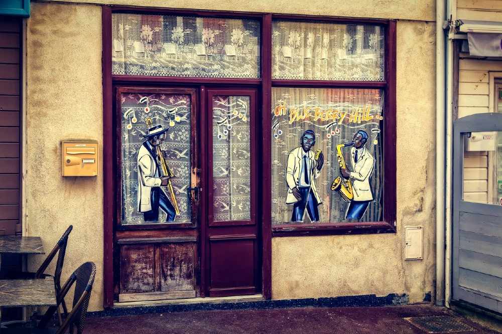 Photo of the front of a pub with window paintings of artists playing jazz music