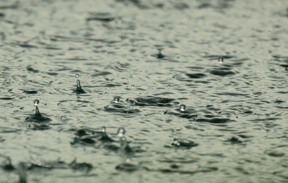 Photo of rain falling onto a pool of water