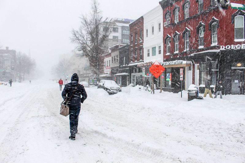Photo of pedestrians walking down a very snowy 14th St NW