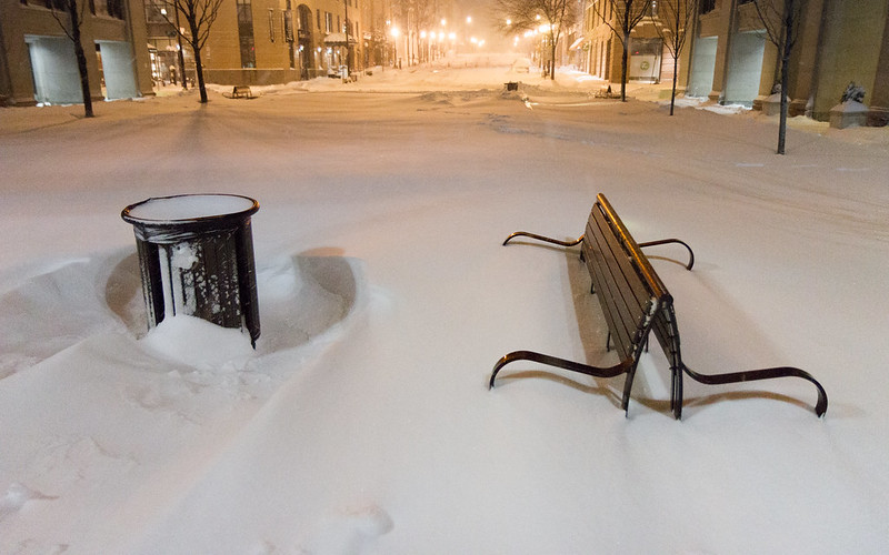 Photo of a large snow fall in Washington, DC. Park benches are nearly covered, with only their back visible.
